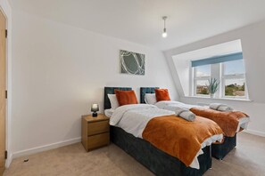 Ein Schlafzimmer mit zwei Betten, einem Nachttisch, einer Lampe, einem Fenster mit Blick und einer Deckenleuchte.