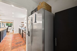 A modern kitchen with a stainless steel refrigerator, a dark cabinet, and a woven basket on top. - The Mad River Lodge: Riverside Escape (Waterville Valley)