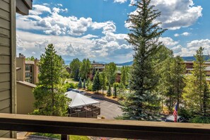 A residential area with a view of a parking lot, trees, and distant mountains. - Steps from Steamboat Resort Condo 1081 (Steamboat Springs)