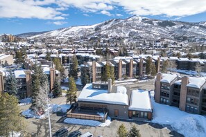 A snow-covered mountain town with modern buildings and a ski resort in the background. - Steps from Steamboat Resort Condo 1081 (Steamboat Springs)