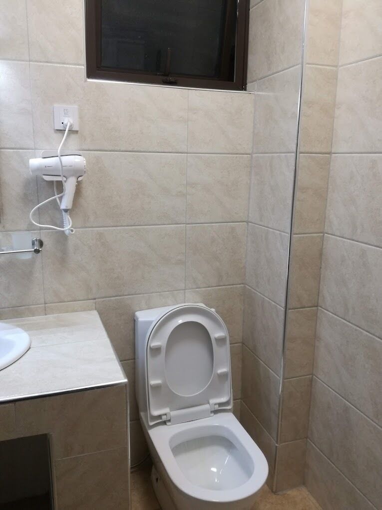 Un baño con inodoro, lavamanos y espejo.