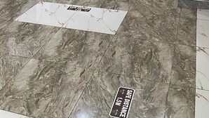 Un pasillo de hotel con piso de mármol, una planta en maceta y un letrero que indica una distancia segura de 1.5 metros.