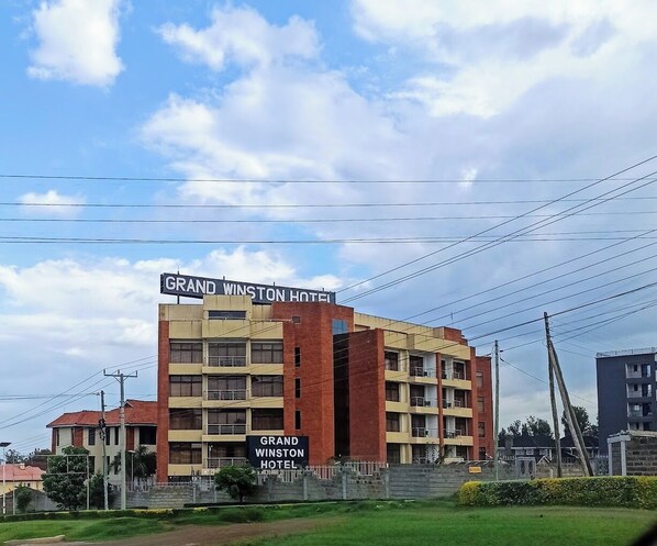A multi-story hotel with a prominent sign reading 'Grand Winston Hotel.'