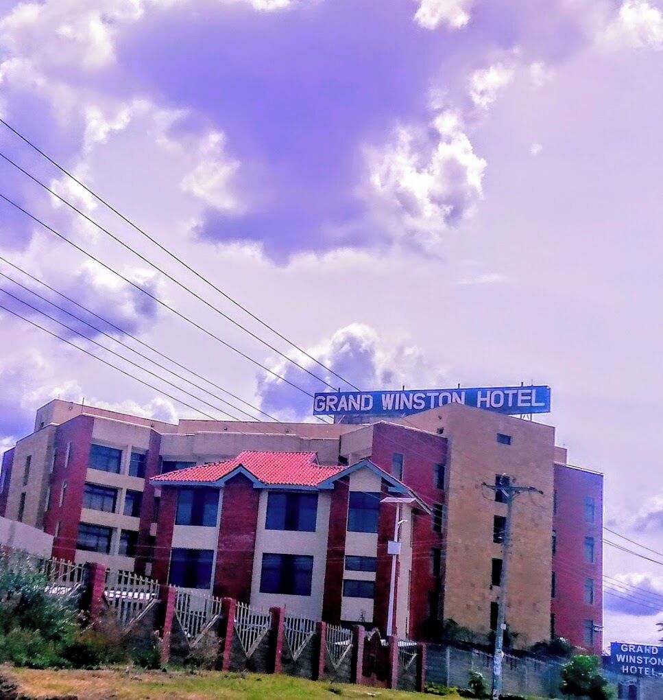 Un hotel con techo rojo y un cartel que dice 'GRAND WINSTON HOTEL'.