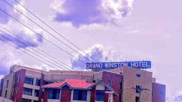 Un hotel con techo rojo y un cartel que dice 'GRAND WINSTON HOTEL'.