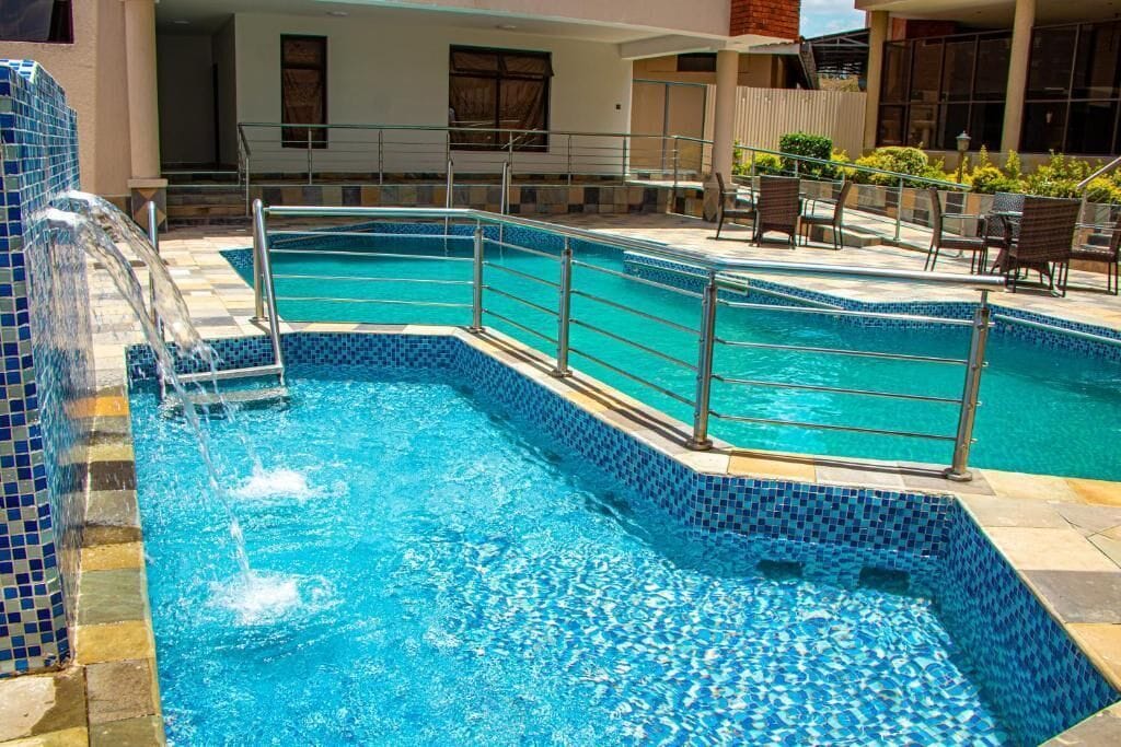 A swimming pool with a tiled edge and a metal safety railing.