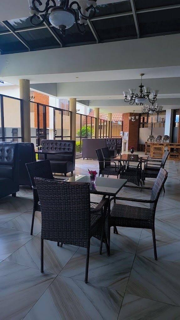 Amplio espacio interior con mobiliario moderno, incluyendo sofás y mesas de comedor, y un techo con detalles decorativos.