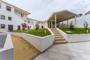 A modern building with a covered staircase, a flat roof, and a small garden area. - GuestReady - Studio near Porto Universities (São Mamede de Infesta)
