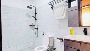 Moderni kylpyhuone, jossa on wc, suihku ja pesuallas.