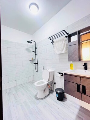Ein modernes Badezimmer mit Toilette, Dusche und Waschbecken.