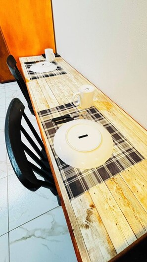 A dining table with a plaid tablecloth, a white mug, and a white plate. - Porto Beach Flats Dolce Vita Piscina 03C (Ipojuca)