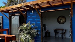 A pool area with a wooden deck, a potted plant, and a seating area with a table and chairs.