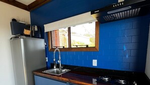 A kitchen with a blue backsplash, a stainless steel refrigerator, a gas stove, and a built-in oven.