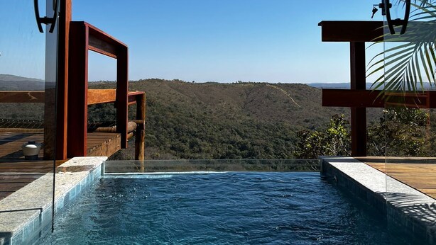 A swimming pool with a view of a hilly landscape.