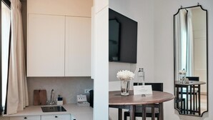 A modern kitchen with white cabinets, a stainless steel sink, and a wooden cutting board.