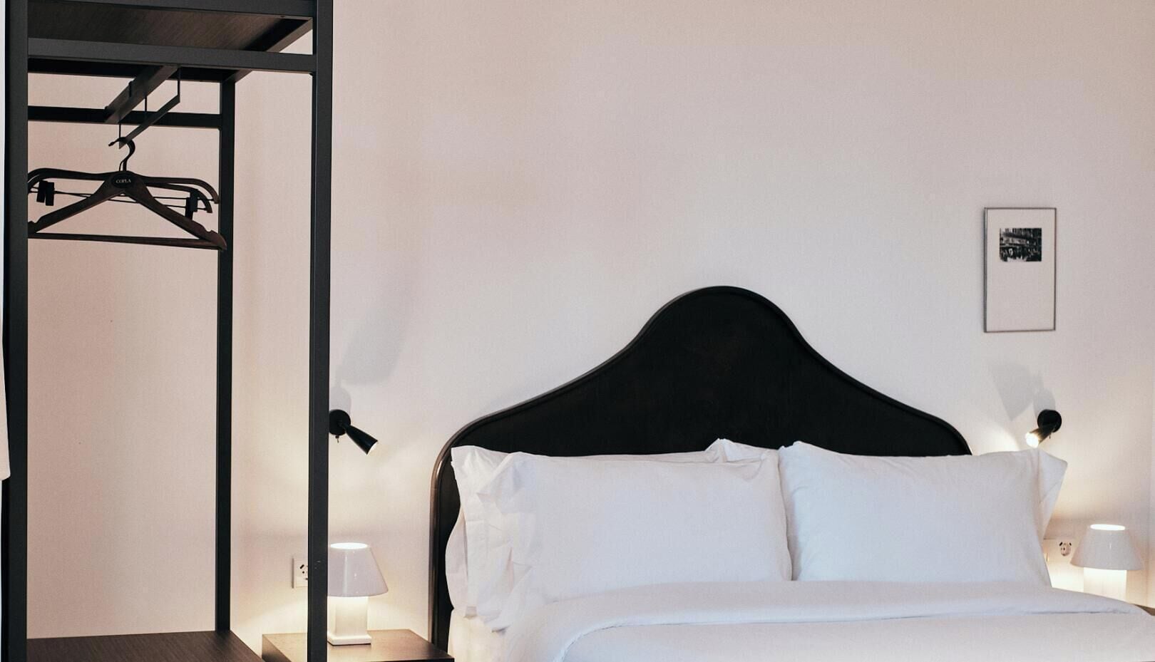 Ein Hotelzimmer mit einem Bett, einem Kleiderschrank und einem Wandbild.