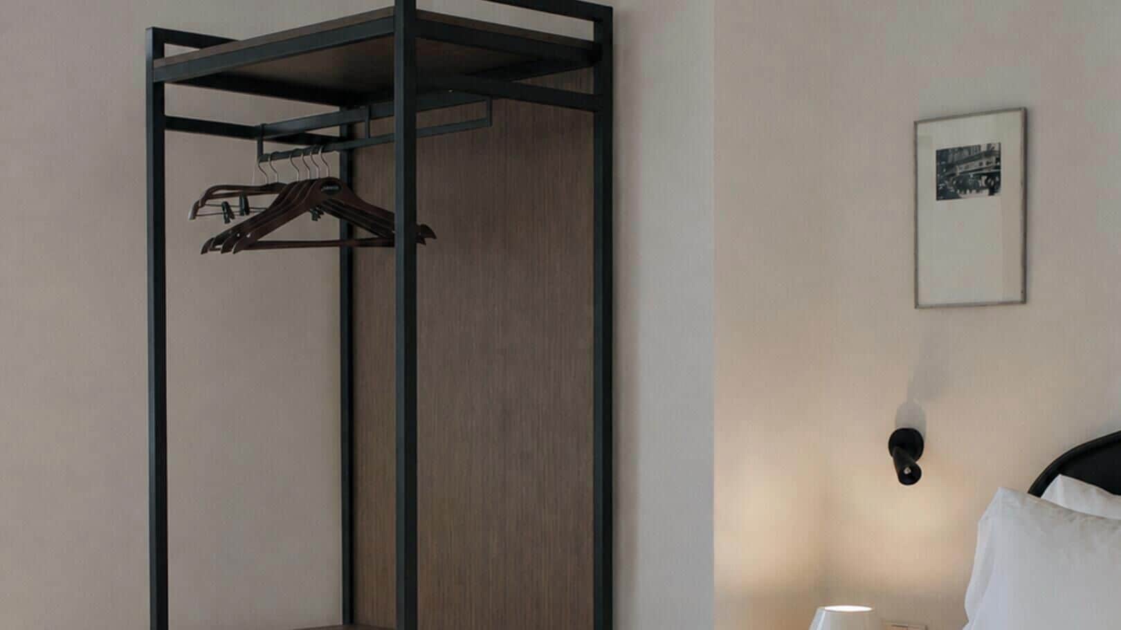 Una habitación con cama, una lámpara de pared y un cuadro enmarcado.