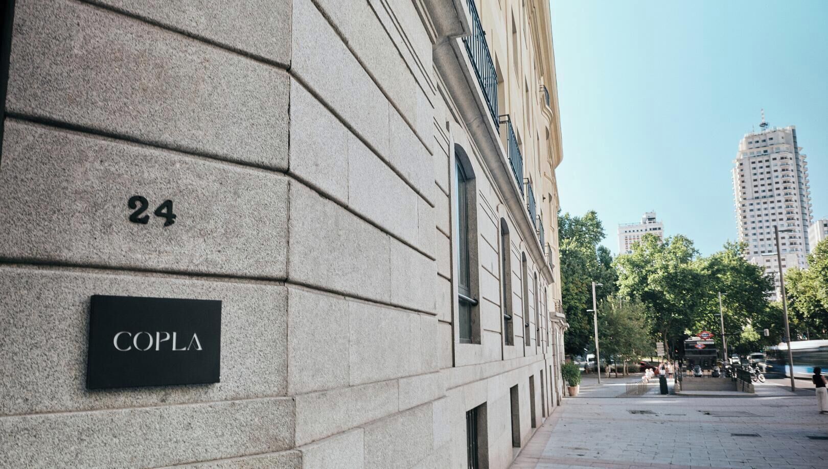Un edificio con fachada de piedra, un letrero que dice 'COPLA' y el número '24' arriba.