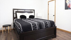 Un letto con una testiera, un comodino e una lampada.
