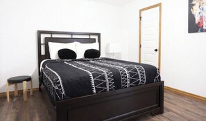 Ein Bett mit Kopfteil, Nachttisch und Lampe.