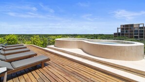 A rooftop terrace with lounge chairs, a hot tub, and a view of greenery and buildings. - Penthouse Unit w/ Spectacular Ocean & Golf Views (Playa del Carmen)