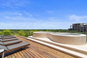 A rooftop terrace with lounge chairs, a hot tub, and a view of greenery and buildings. - Penthouse Unit w/ Spectacular Ocean & Golf Views (Playa del Carmen)