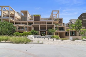 A multi-story residential building with balconies, a central courtyard, and a modern architectural design. - Penthouse Unit w/ Spectacular Ocean & Golf Views (Playa del Carmen)