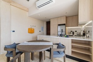 A modern kitchen with a central island, built-in cabinets, and a stainless steel range hood. - Túumben: Penthouse Unit w/ Spectacular Ocean & Golf Views (Playa del Carmen)