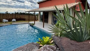 A swimming pool with a house in the background.