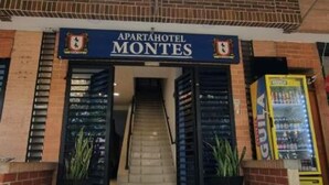 Um edifício com uma placa indicando 'APARTAHOTEL MONTES' e uma escadaria que leva à entrada.