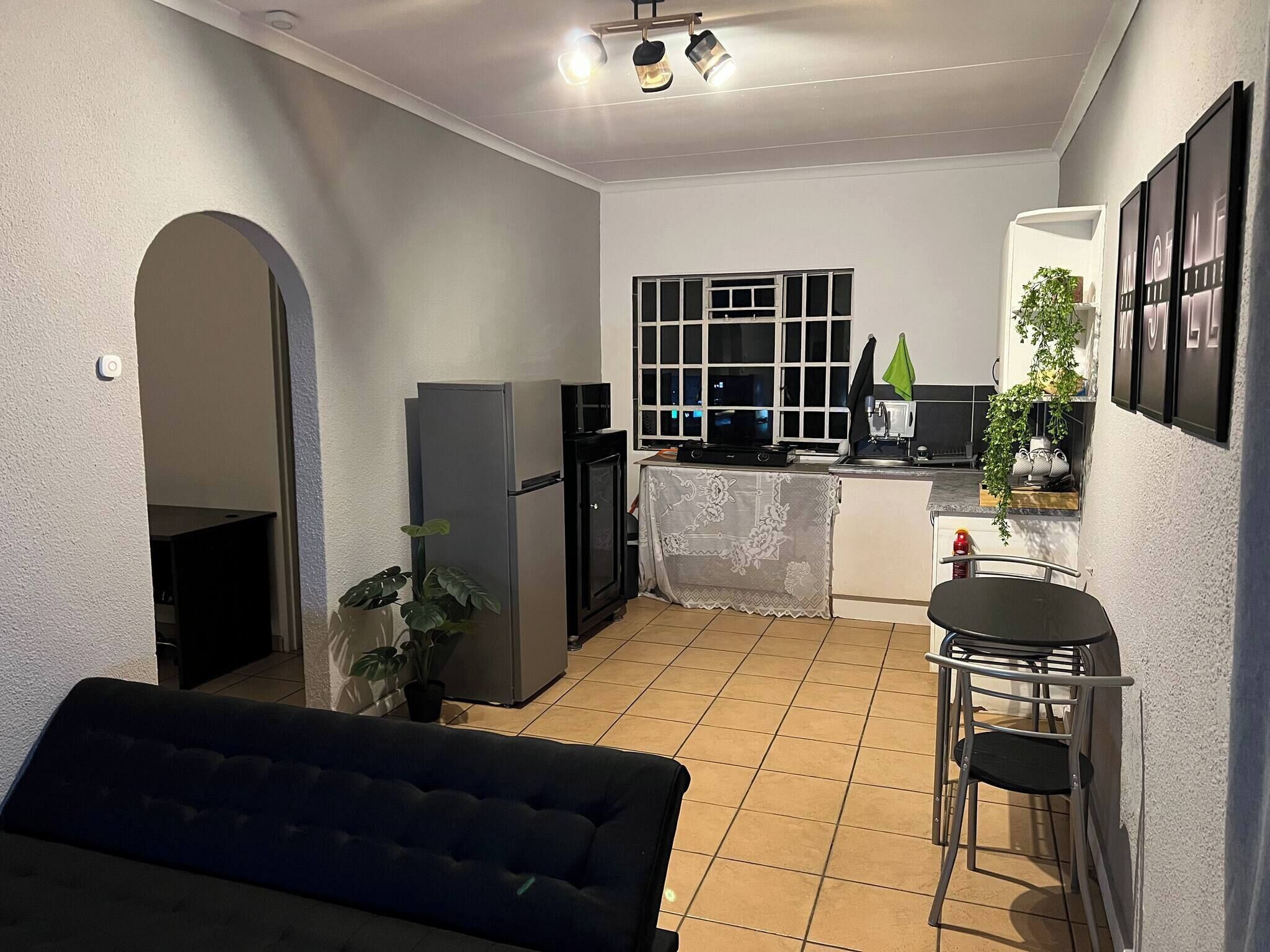 A compact living space with a kitchenette, a dining area, and a sofa.