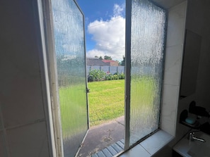 Een badkamer met een douche, wastafel en toilet.