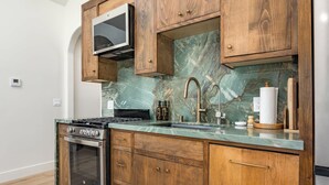 A kitchen with a built-in oven, a stove, a microwave, and wooden cabinets. - Luxury Capitola Retreat | Hot Tub | Blocks to Sand (Capitola)