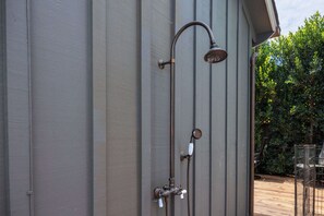 A metal showerhead attached to a wall with a vertical pipe and a valve. - Luxury Capitola Retreat | Hot Tub | Blocks to Sand (Capitola)