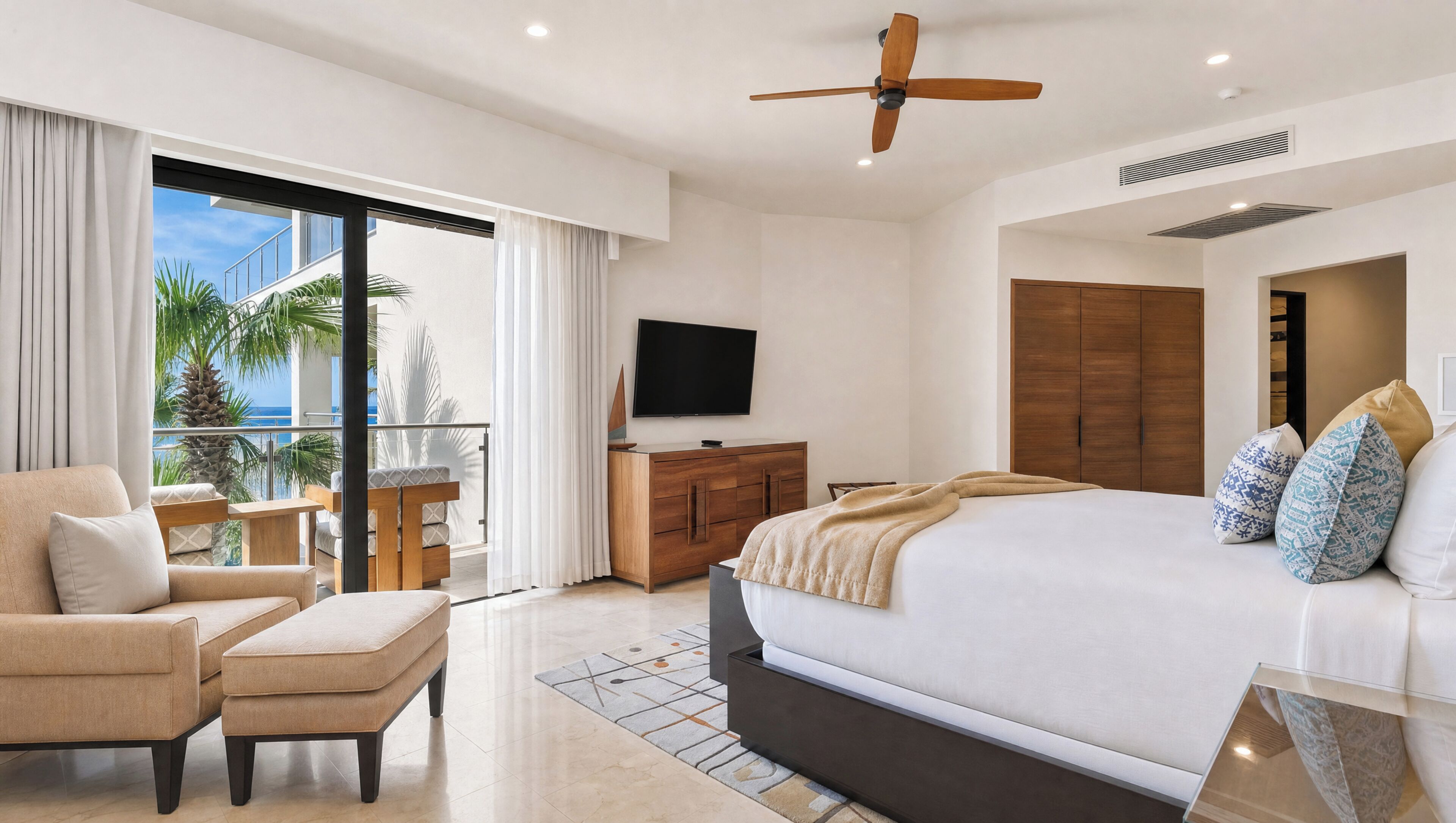 Ein Hotelzimmer mit Bett, Fernseher, Balkon mit Aussicht und Deckenventilator.