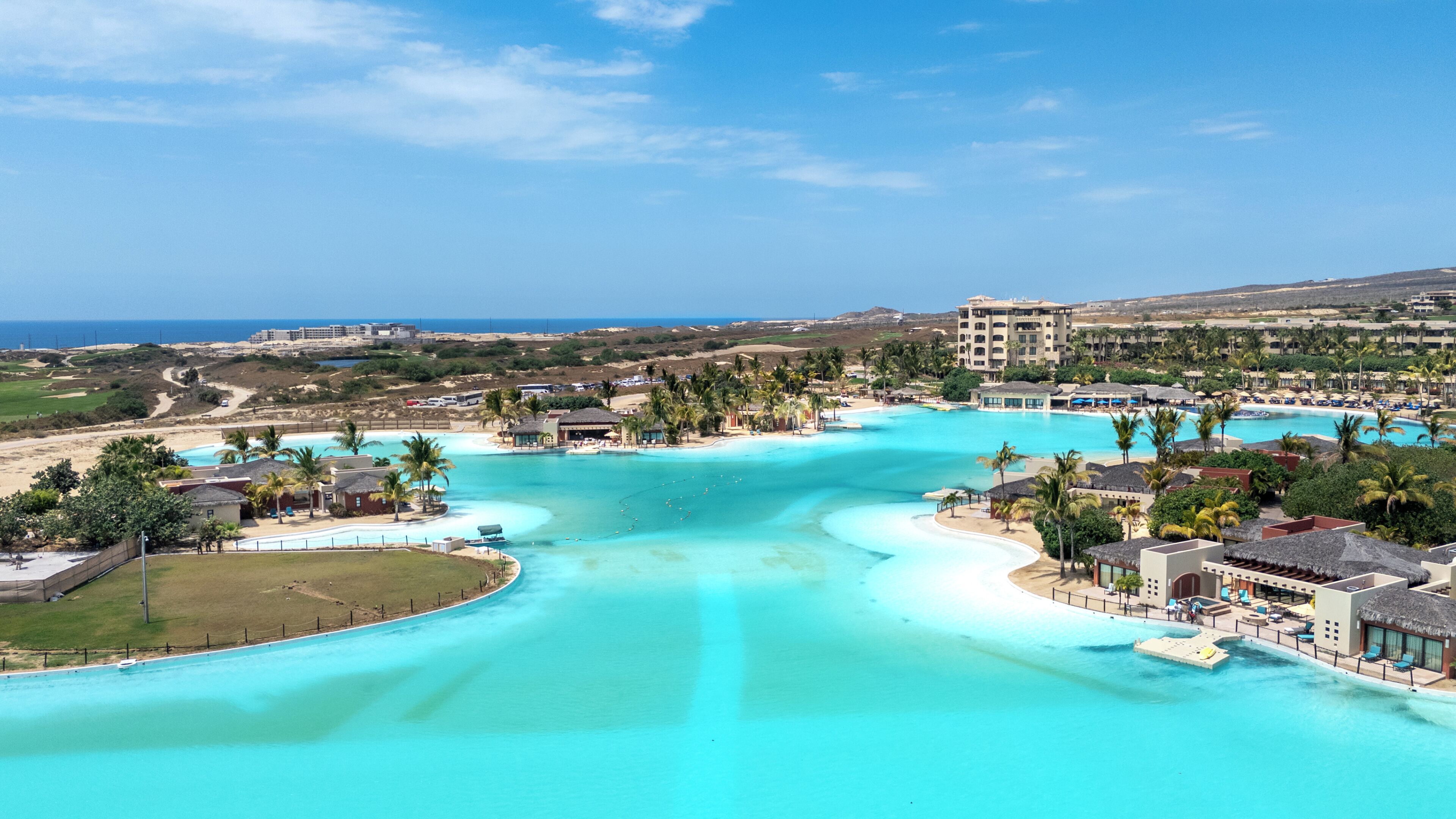A resort with a large pool, beachfront, and a view of the ocean.