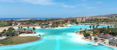 A resort with a large pool, beachfront, and a view of the ocean.