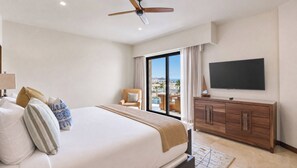 Ein Hotelzimmer mit Bett, Fernseher, Deckenventilator, Fenster mit Blick und einem Holzschrank.
