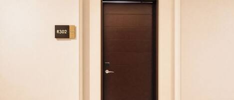 A closed door with a keyhole and a door handle. A room number sign 'R302' is visible to the left.