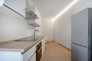 A modern kitchen with a built-in stove, a sink, and a refrigerator. - Apartment 'Appartamento con 1 camera da letto, balcone e vista sulla città' (Polignano a Mare)
