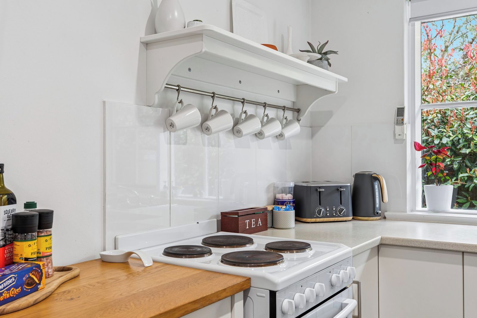 A kitchen with a white stove, a coffee maker, and a toaster on the counter.