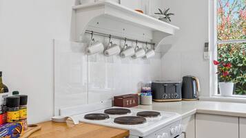 A kitchen with a white stove, a coffee maker, and a toaster on the counter.