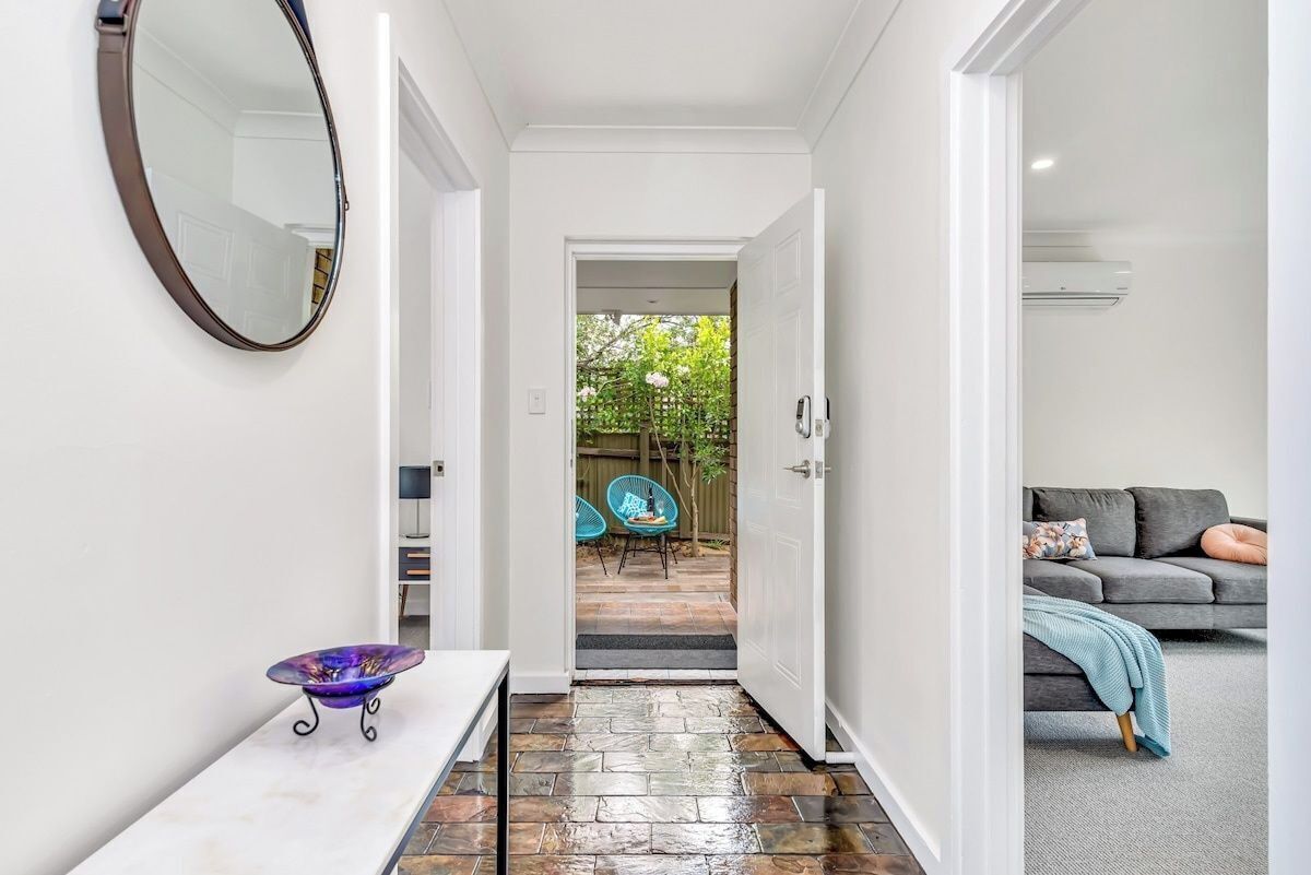 A hallway with a white door leading to a patio area.