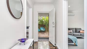 A hallway with a white door leading to a patio area.