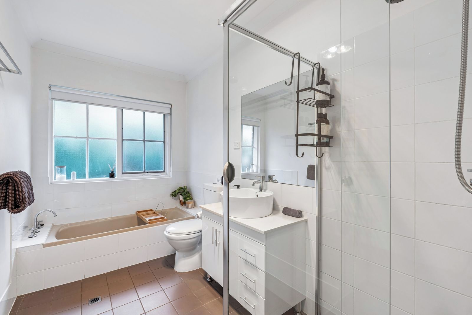 A modern bathroom with a bathtub, toilet, and shower area.