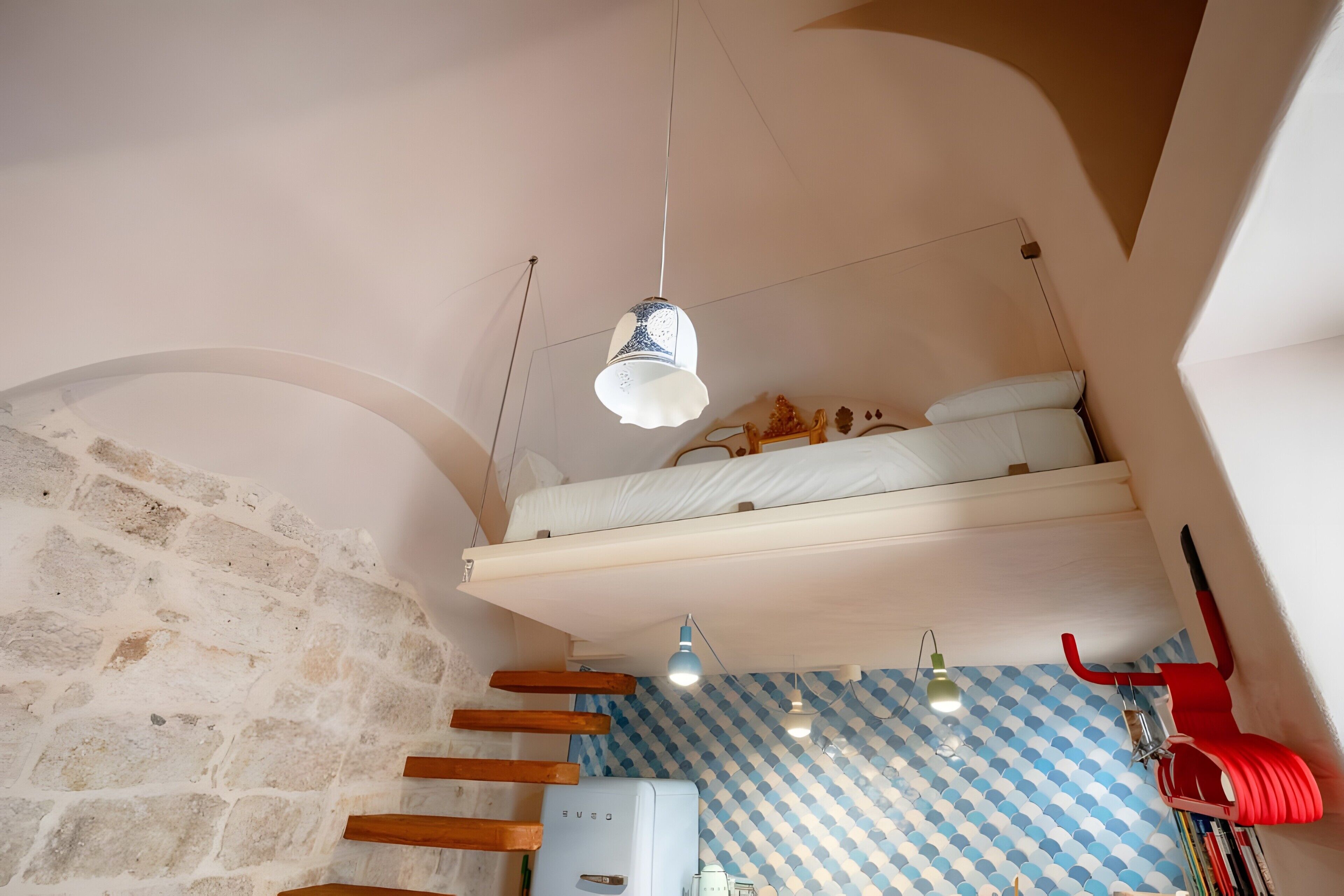 Una habitación pequeña con literas, una kitchenette y un papel tapiz estampado.