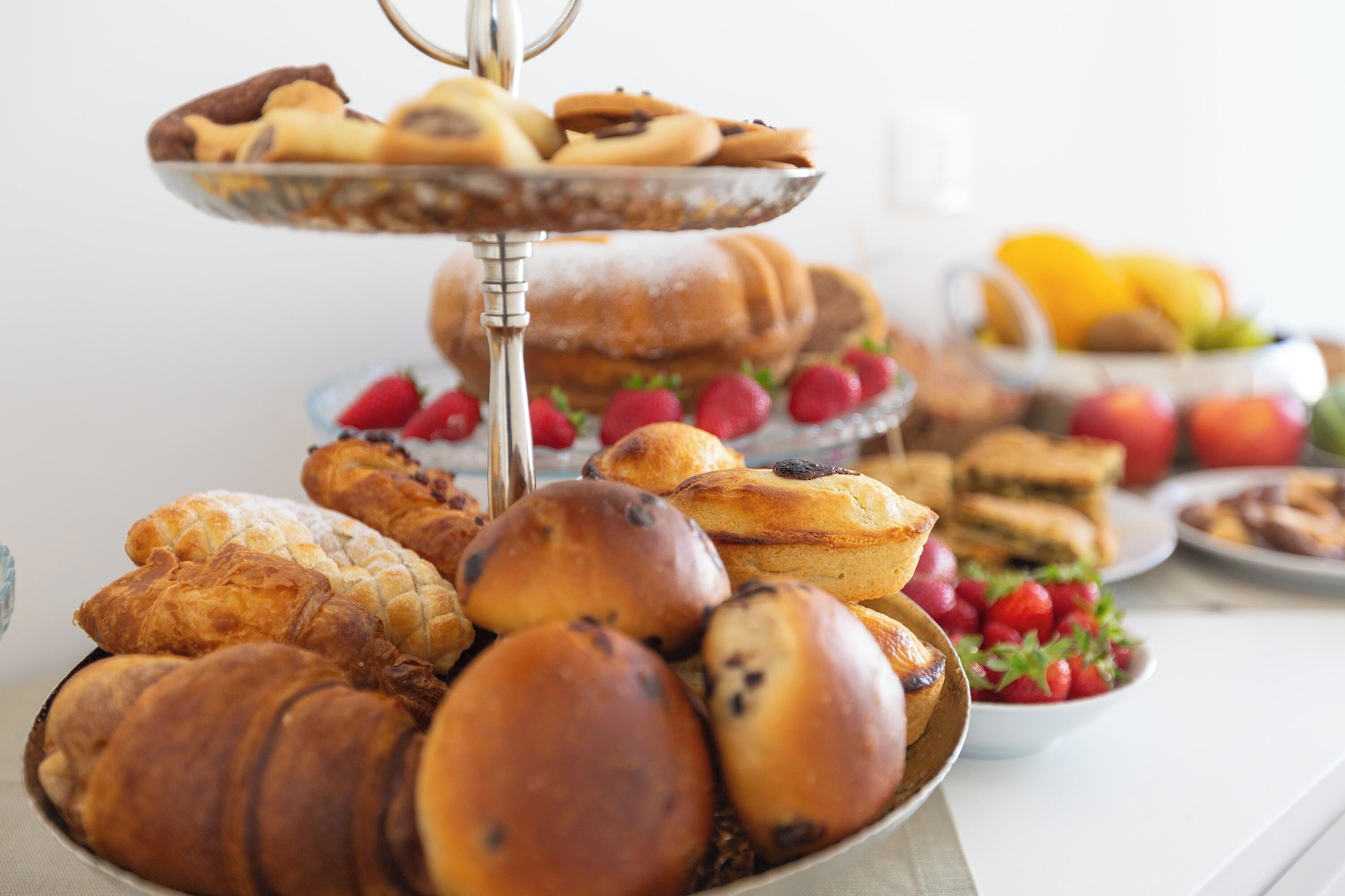 A multi-tiered display of pastries and fruits on a table.