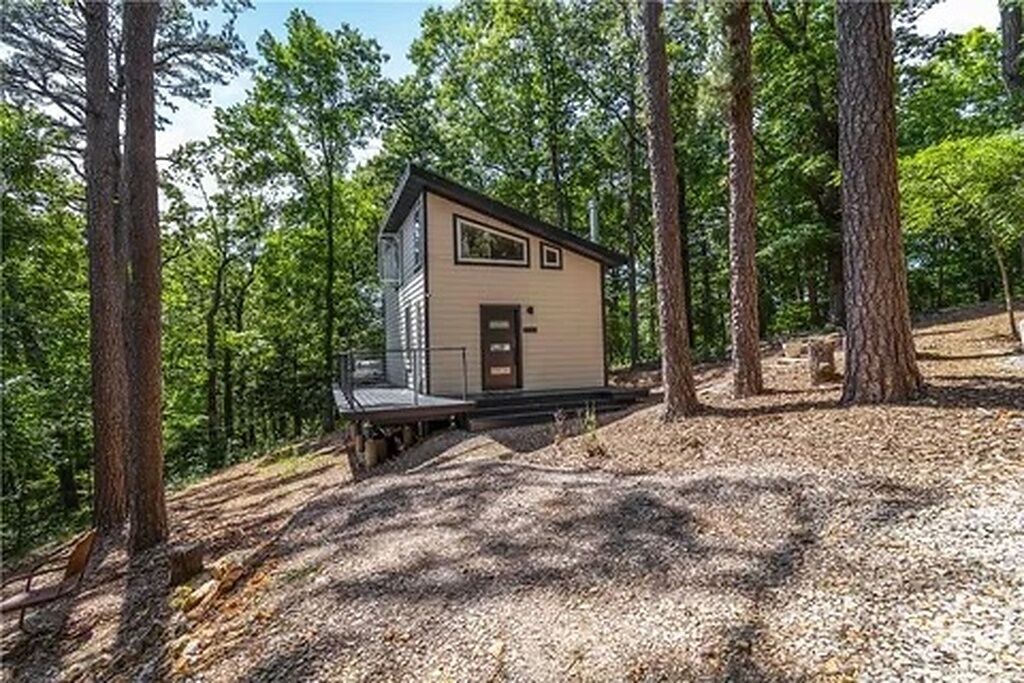 A small cabin with a flat roof, a front door, and a small porch area.
