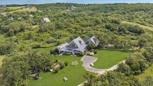 A large house surrounded by lush greenery and a golf course.
