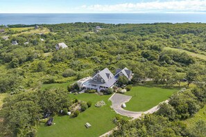 A large house surrounded by lush greenery and a golf course.